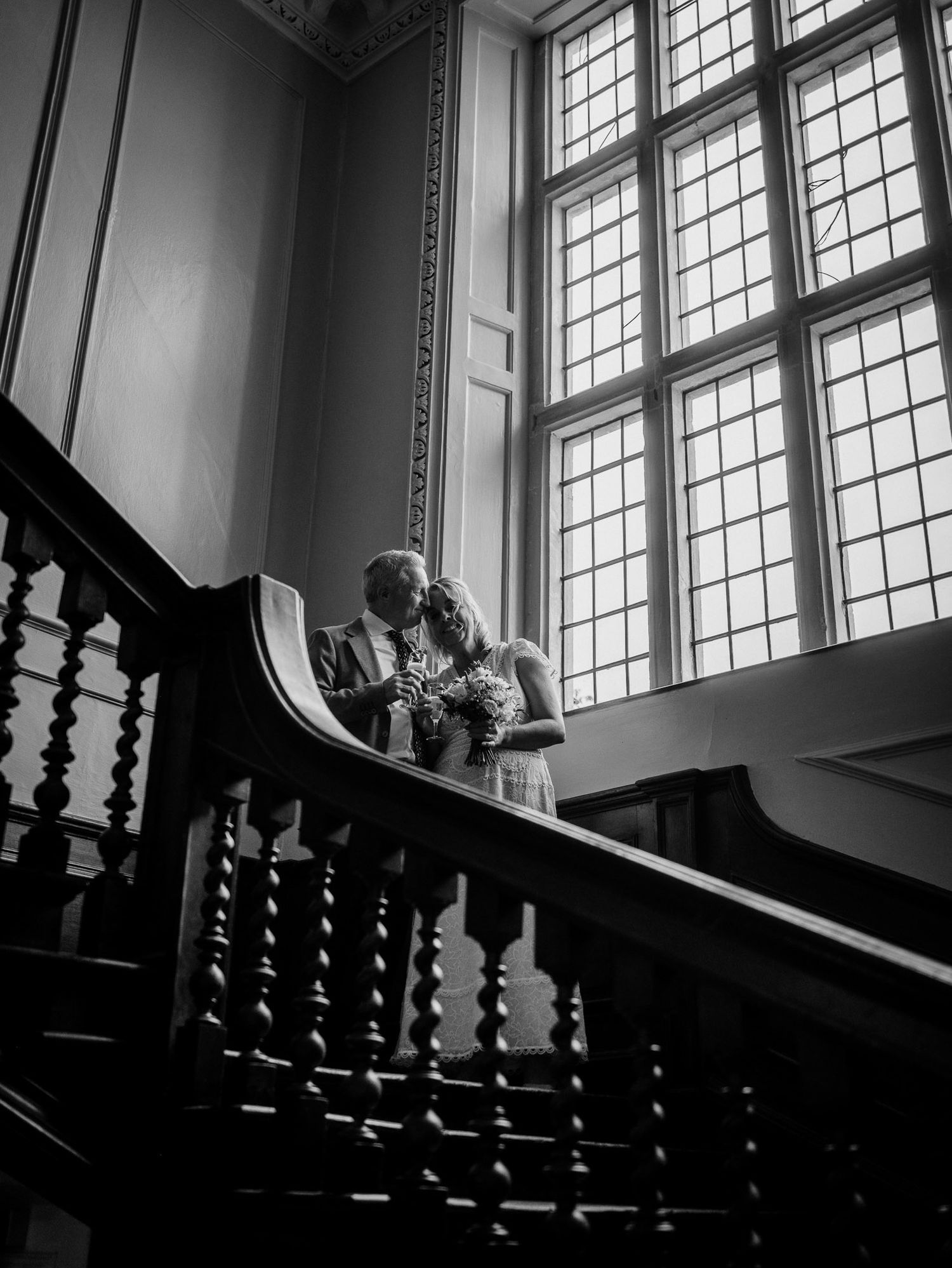 Dramatic black and white staircase photo with large windows and natural light.