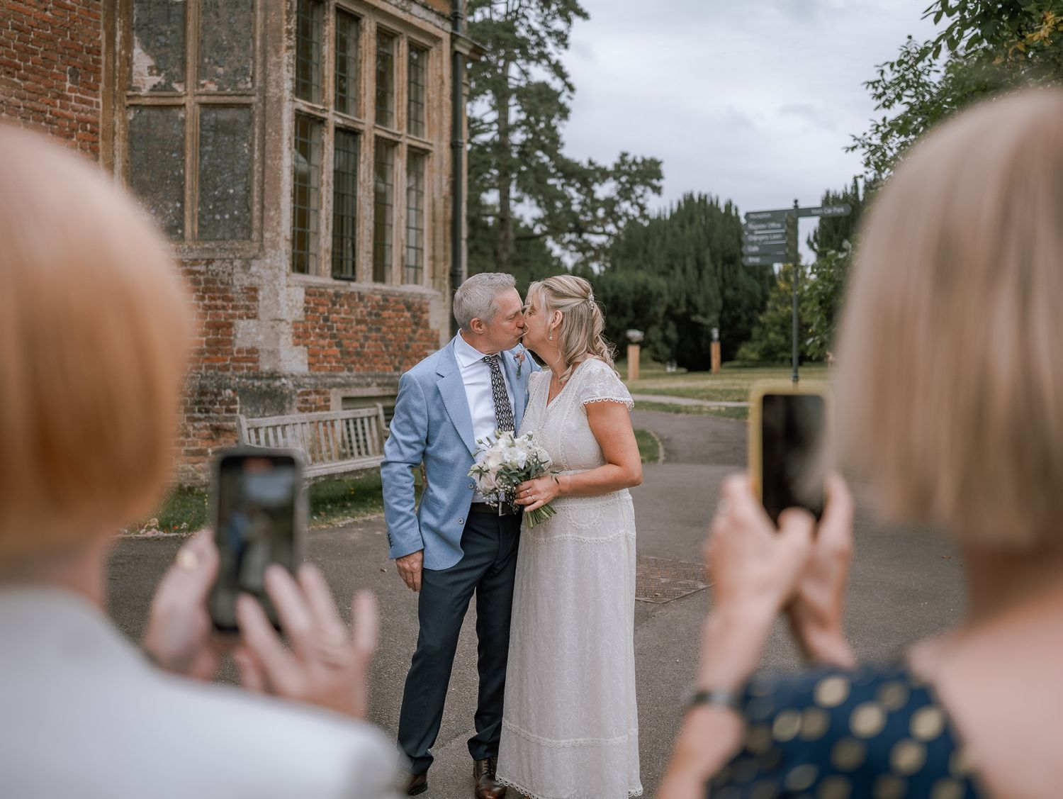 Wedding guests celebrating outside a historic brick building.