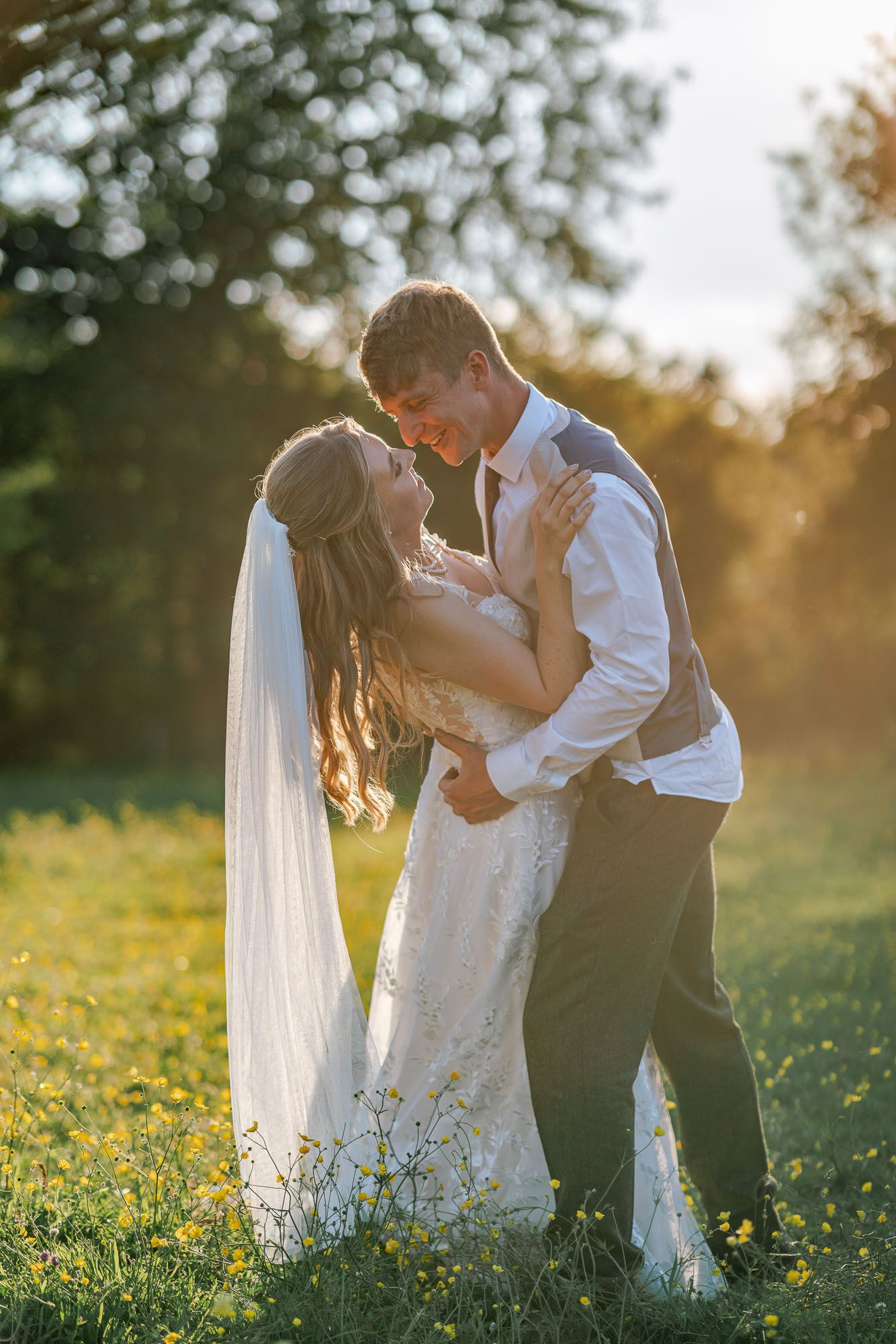 A romantic moment captured in a sunlit meadow filled with yellow flowers.