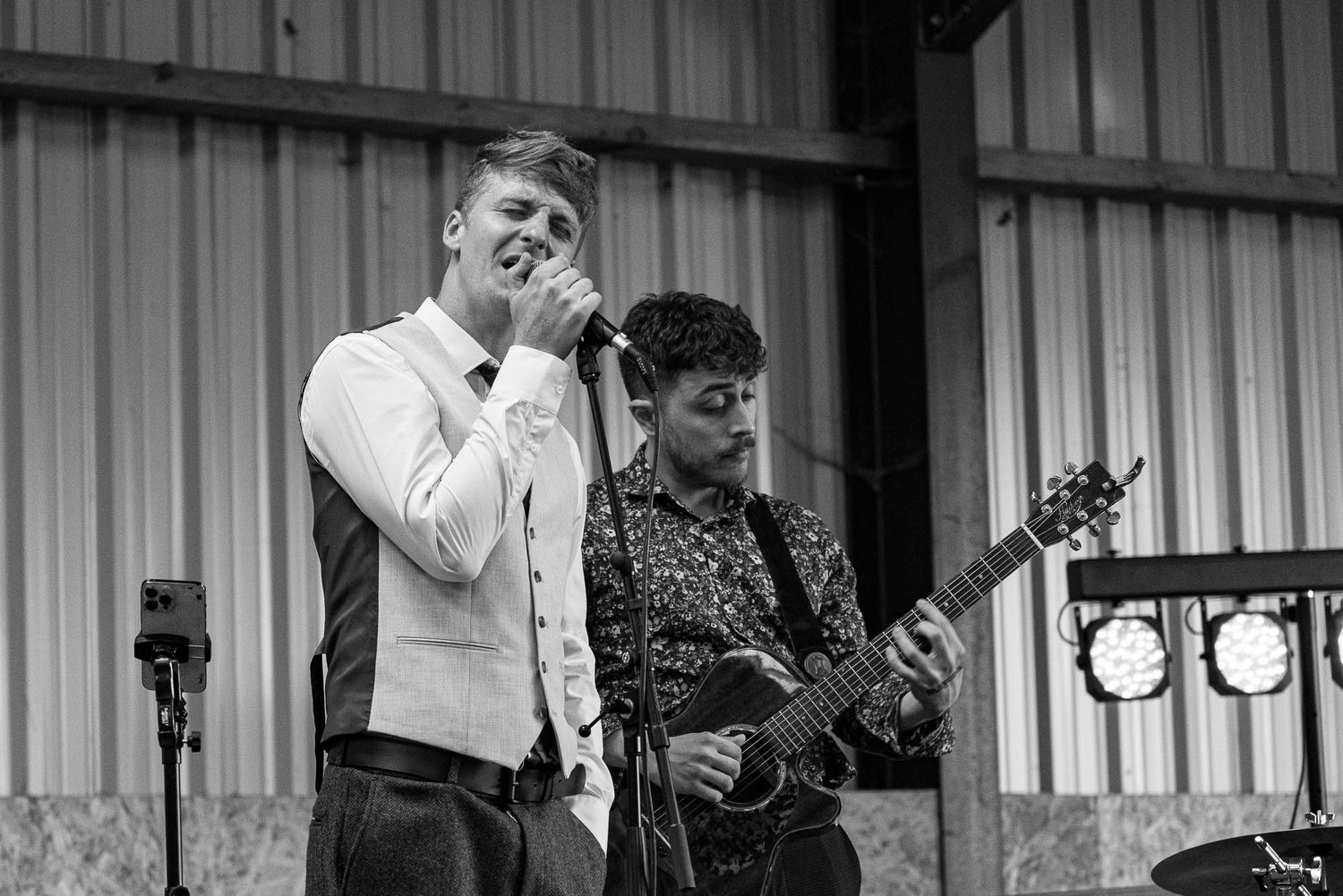 Musicians perform at a wedding reception in black and white photography.