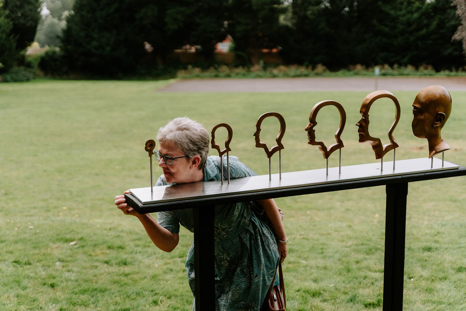 People playing on wooden seesaws in a garden setting.