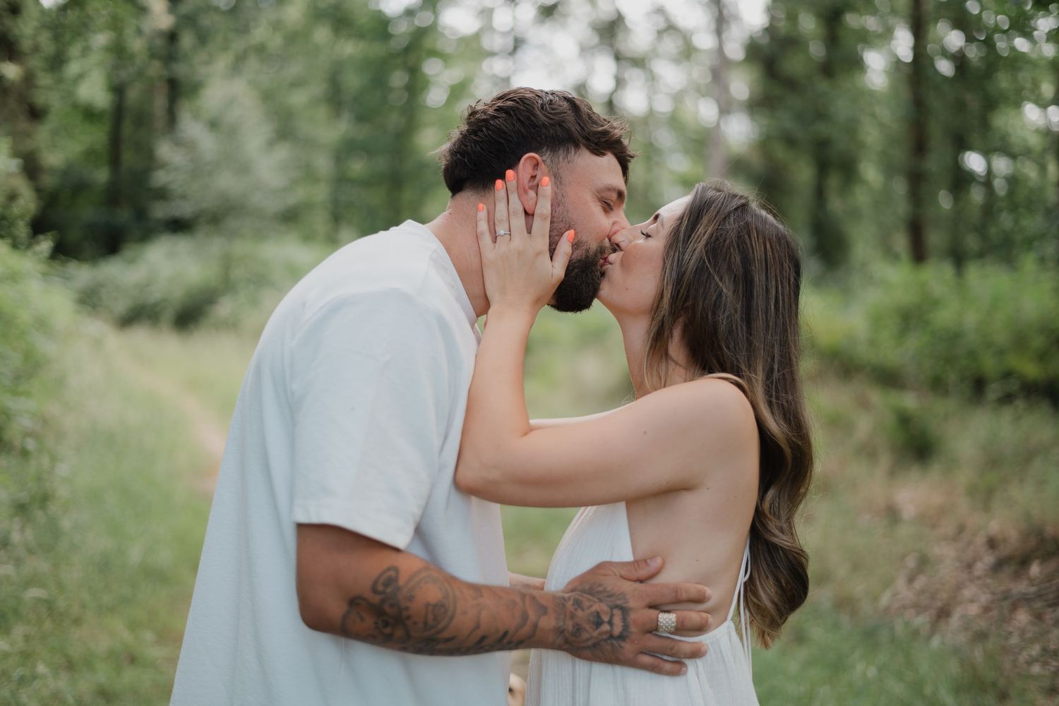 Romantic couple's photoshoot in a lush green forest setting.