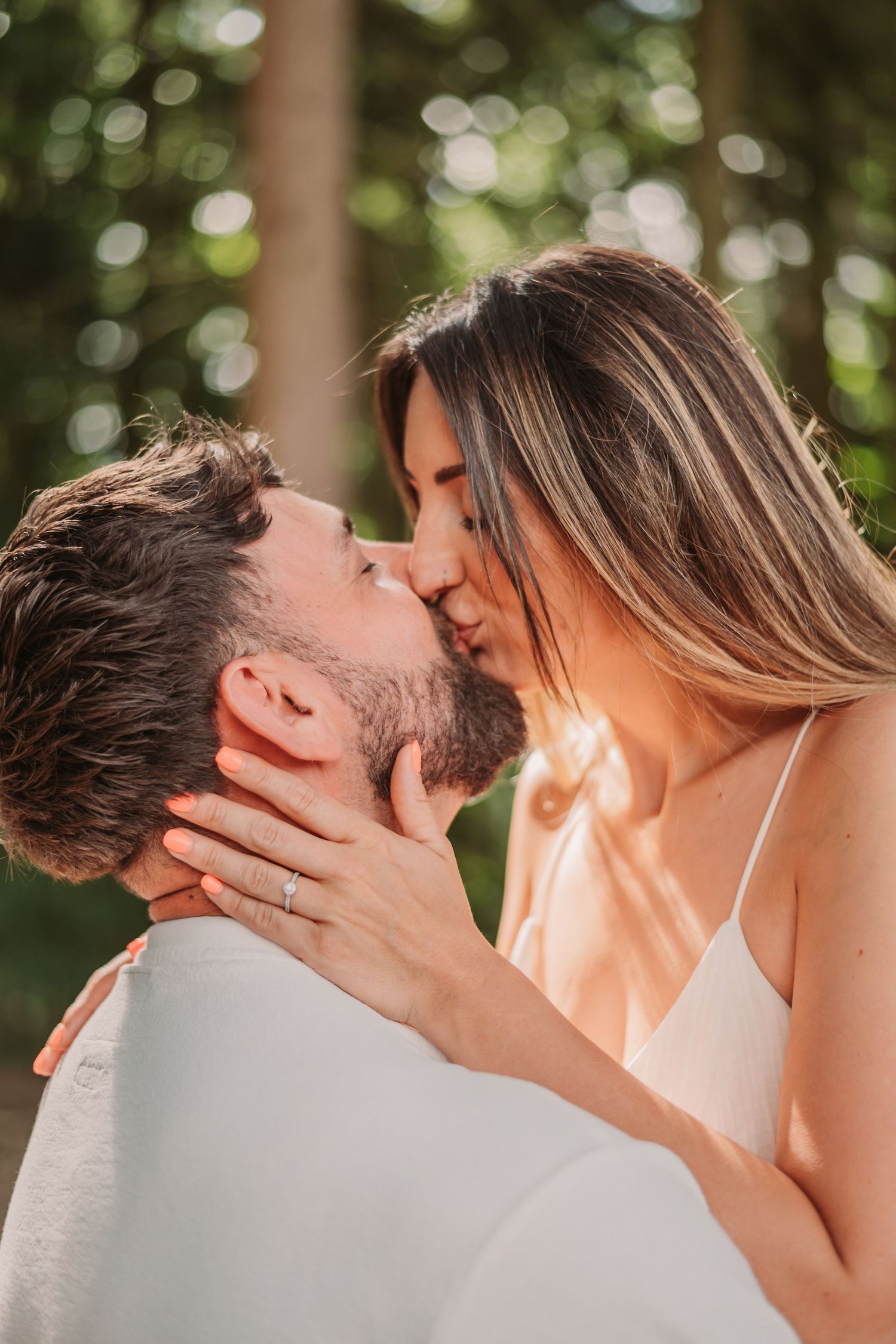 A romantic sequence showing a tender kiss between a couple in a sunlit outdoor setting.