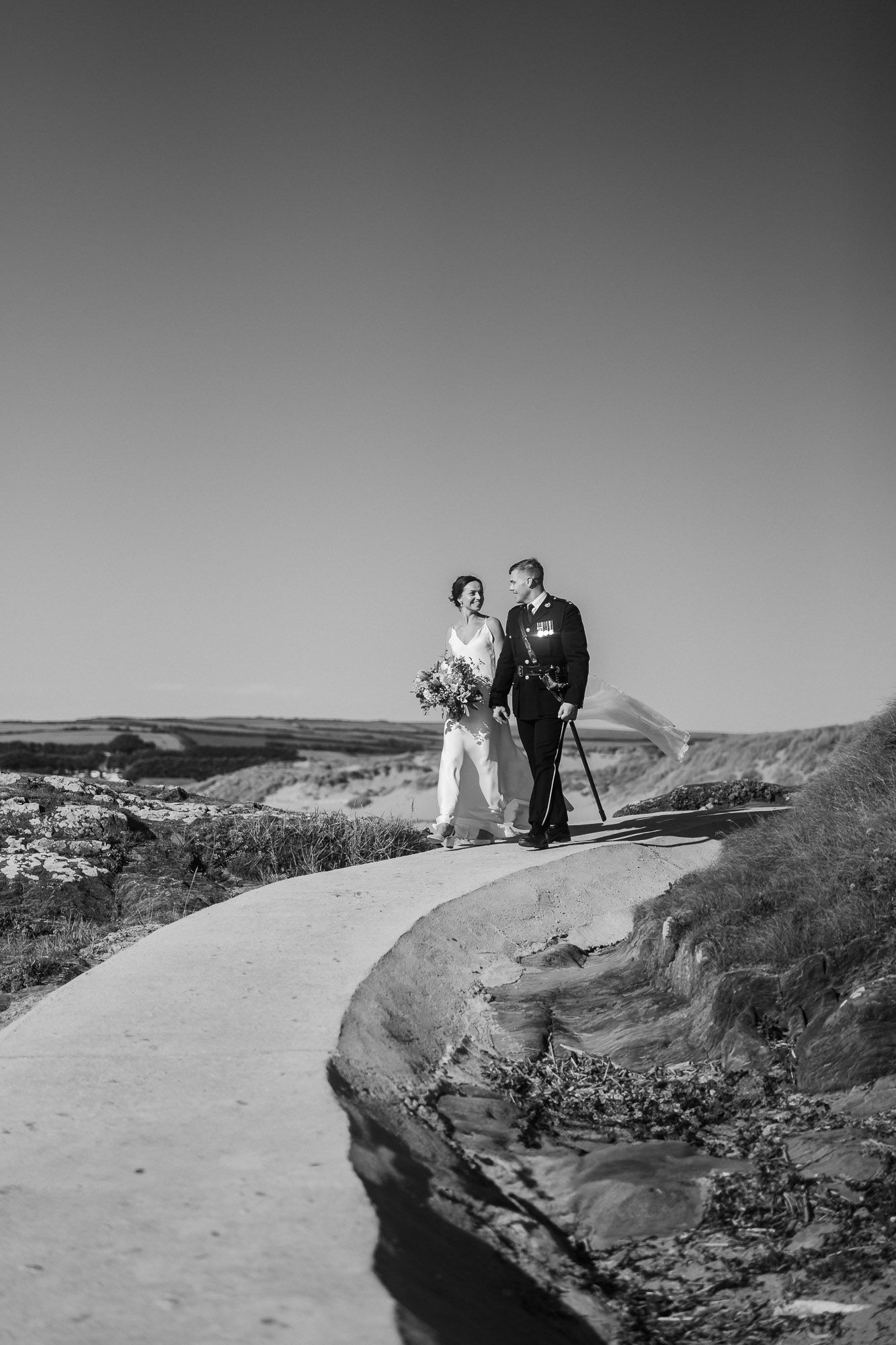 Black and white wedding photography on dramatic coastal cliffs.