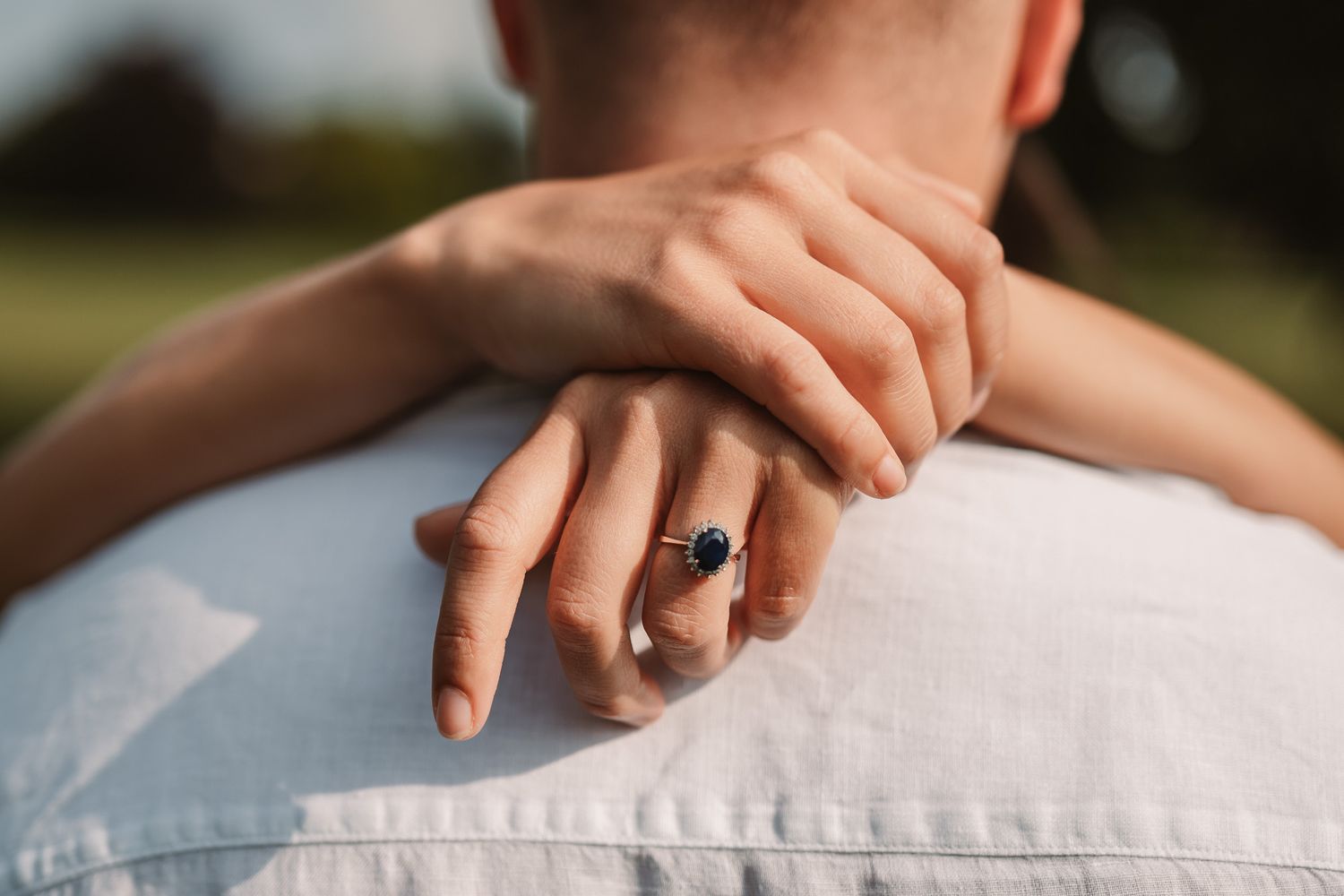 Close-up detail shot of hands tenderly touching during intimate moment.