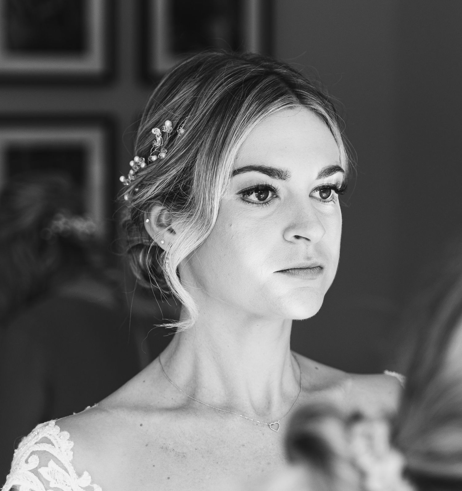 Black and white portrait of bride wearing delicate hair accessories and lace dress.