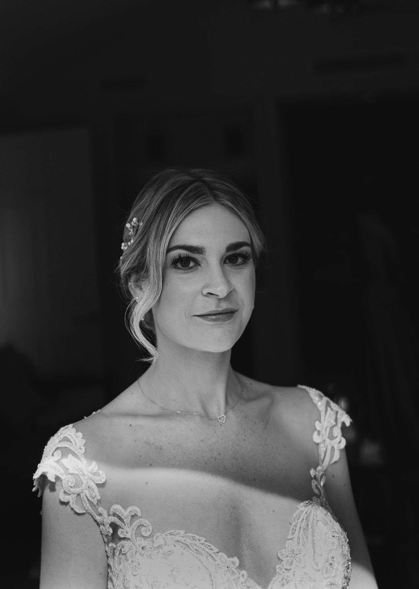 Classic bridal portrait in black and white showing intricate lace dress details.