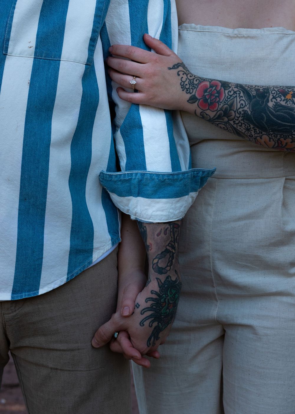 Close-up of casual summer outfits with blue striped patterns and visible tattoos.