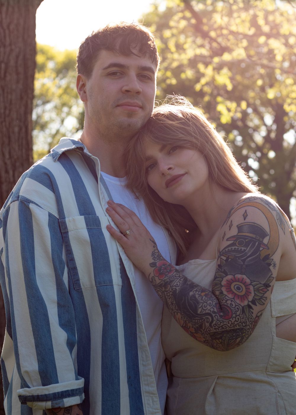 A romantic sunset photoshoot in a park with soft golden lighting.