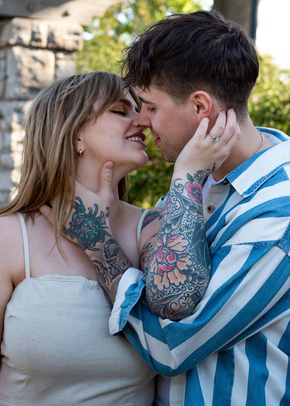 An intimate moment between a couple with visible floral tattoo artwork.