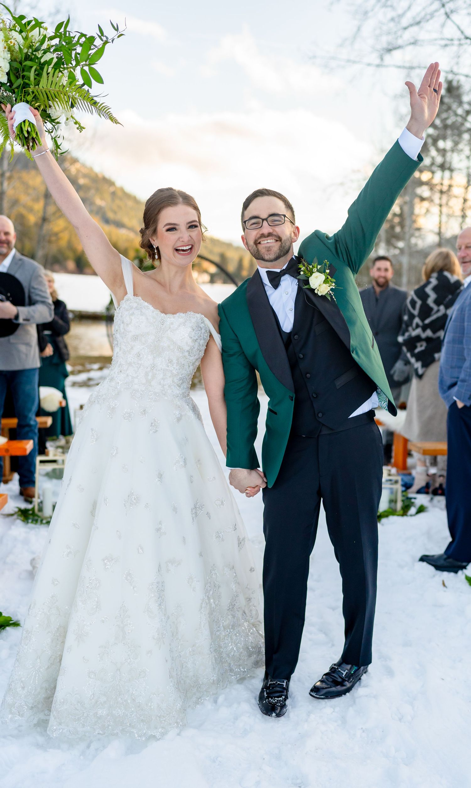 A joyful wedding celebration moment in the snow with guests and decorative outdoor setting.