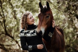 Dame og fri hest i skoven kigger på hinanden