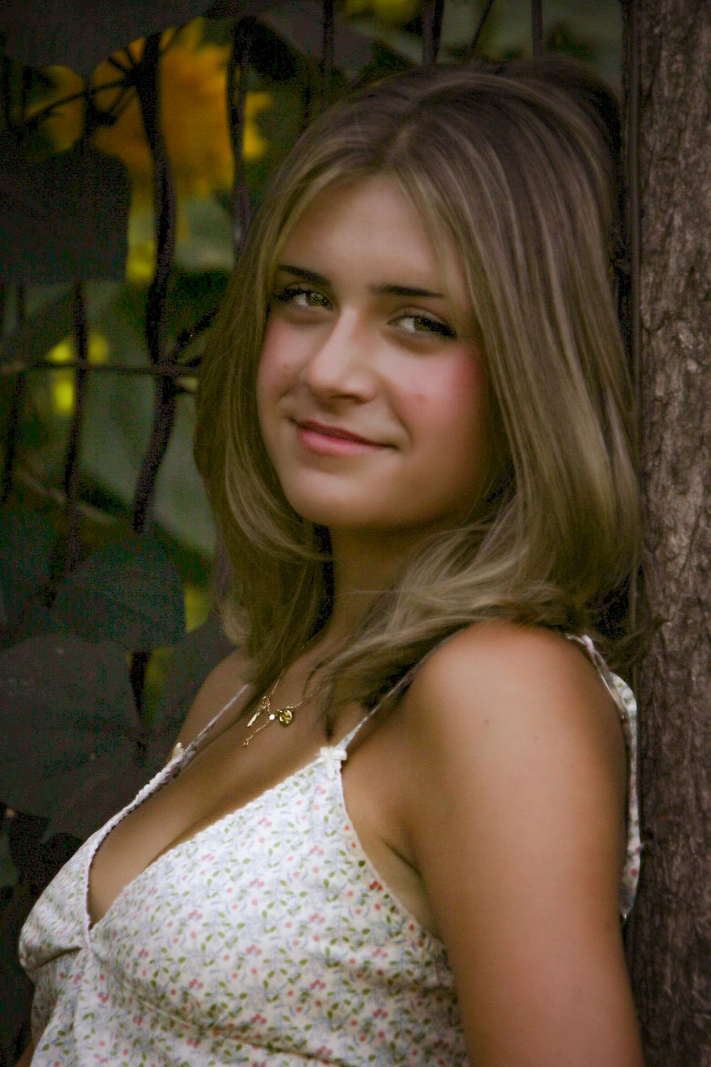 Summer portrait with white lace dress against natural outdoor setting.