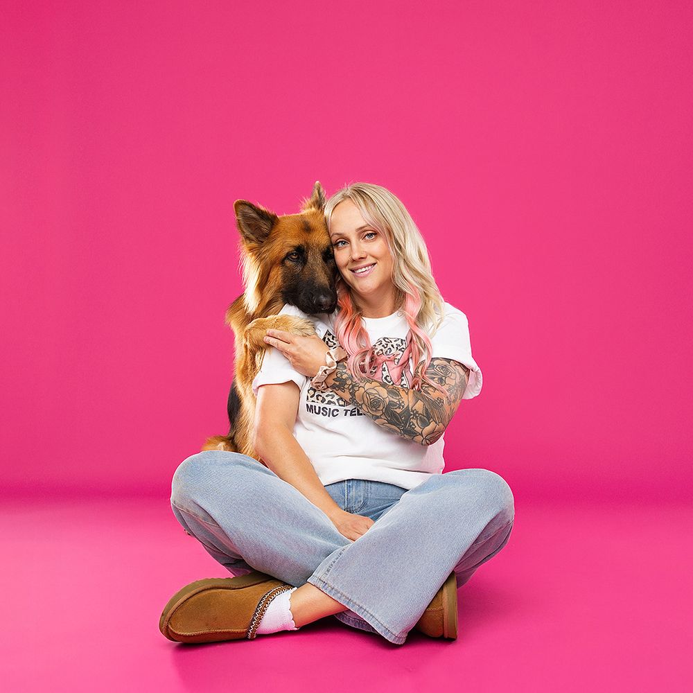 Studio photography setup with pink decor, flowers, and camera equipment.