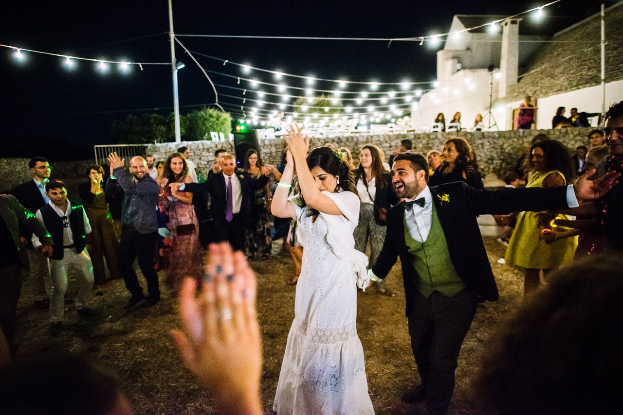 Festive nighttime wedding reception with string lights illuminating the dance floor.
