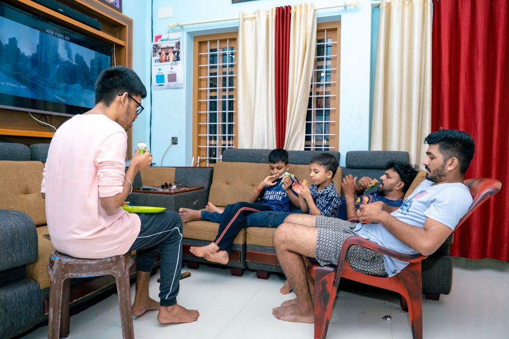 Group of friends relaxing in casual attire while hanging out in a living room setting.