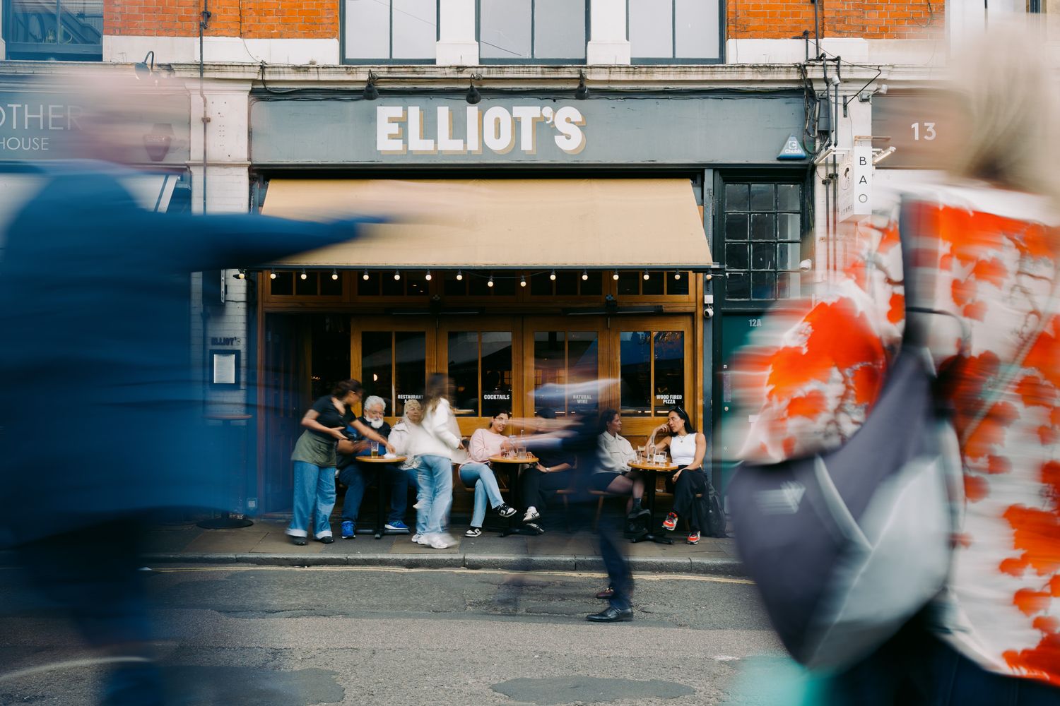 Exterior view of Elliot's storefront with blurred motion effect in urban setting.