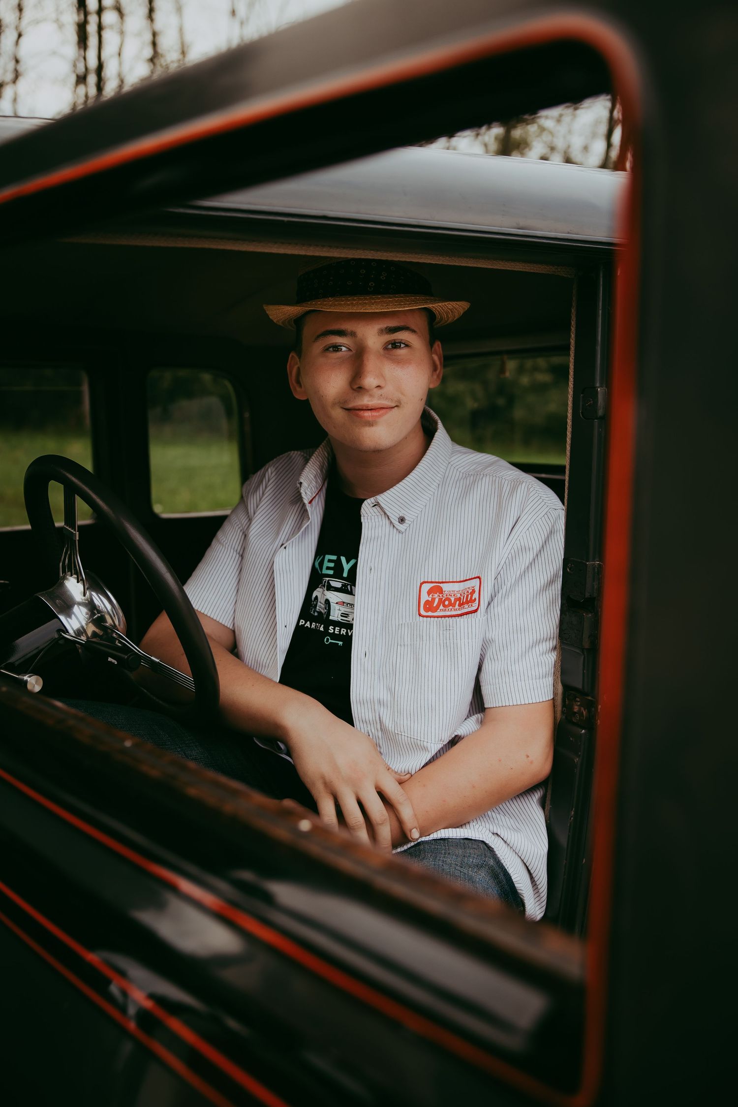 Vintage-style photo of someone in a work uniform sitting in an old truck.