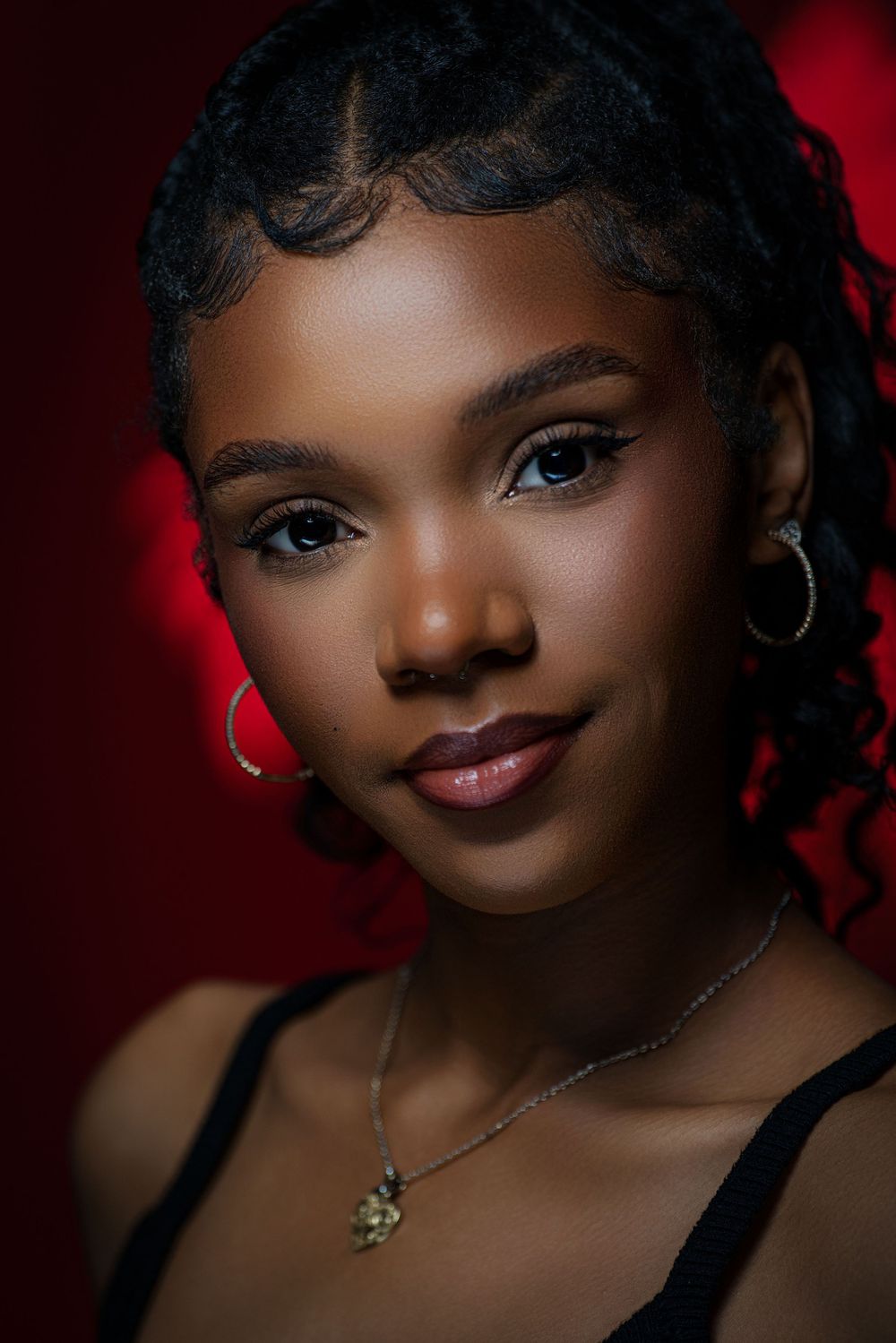 Portrait series with dramatic red lighting showing close-up beauty shots against a dark background.
