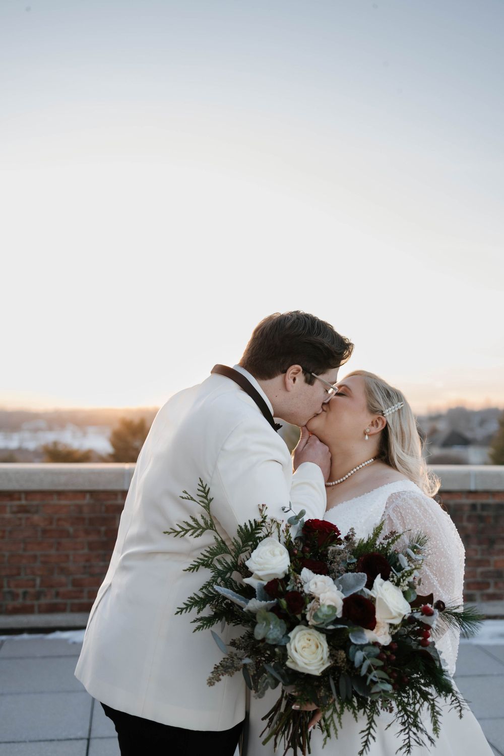 Bride and groom kissing outside on a cold winter wedding day
