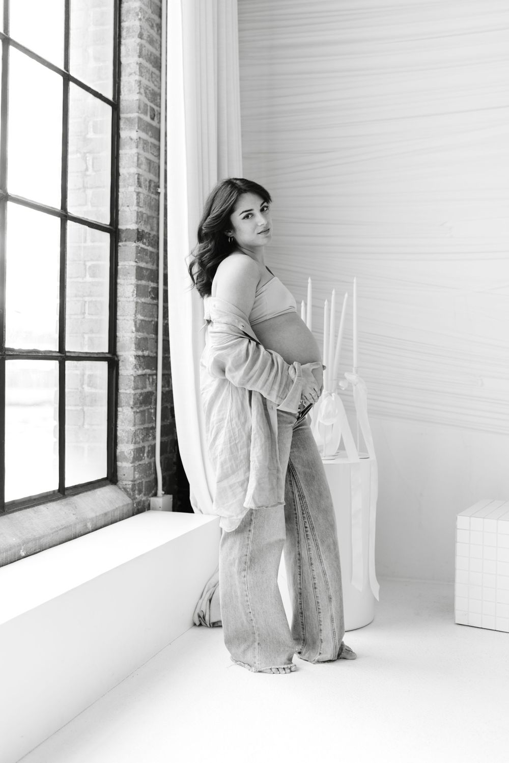 Mom to be wearing jeans at a maternity shoot at Mint Room Preto Loft by Toronto photographer Jess GC Photography