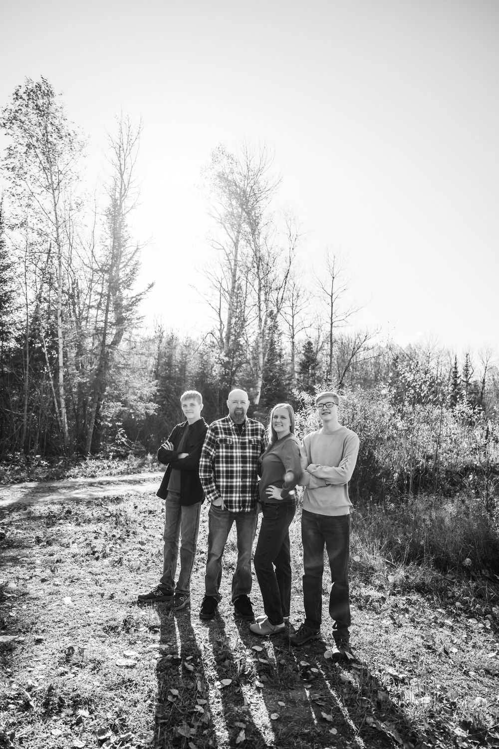Ryan and Michelle posing with boys with trees in background in black and white