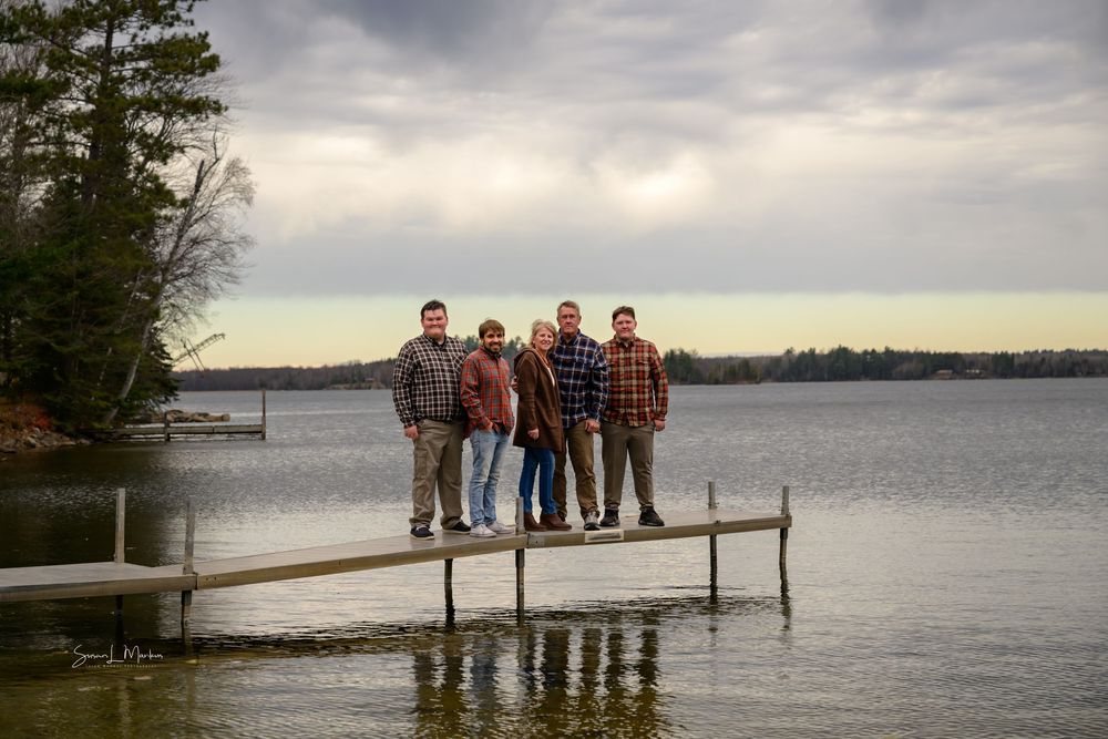 Dock on lake with family of five looking at camera Orr, Minnesota