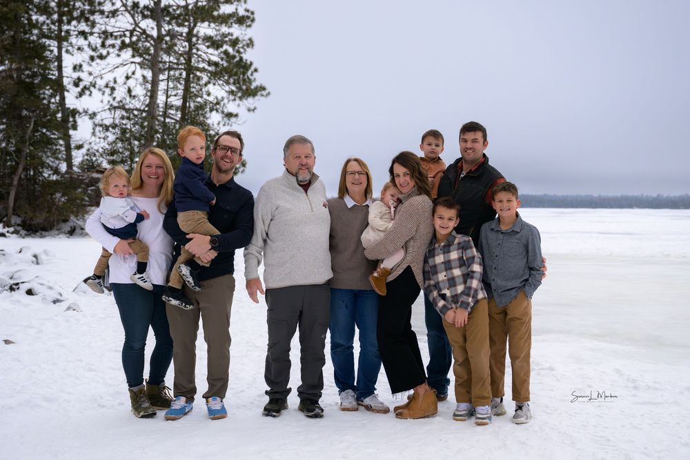 Extended family posing on lake background