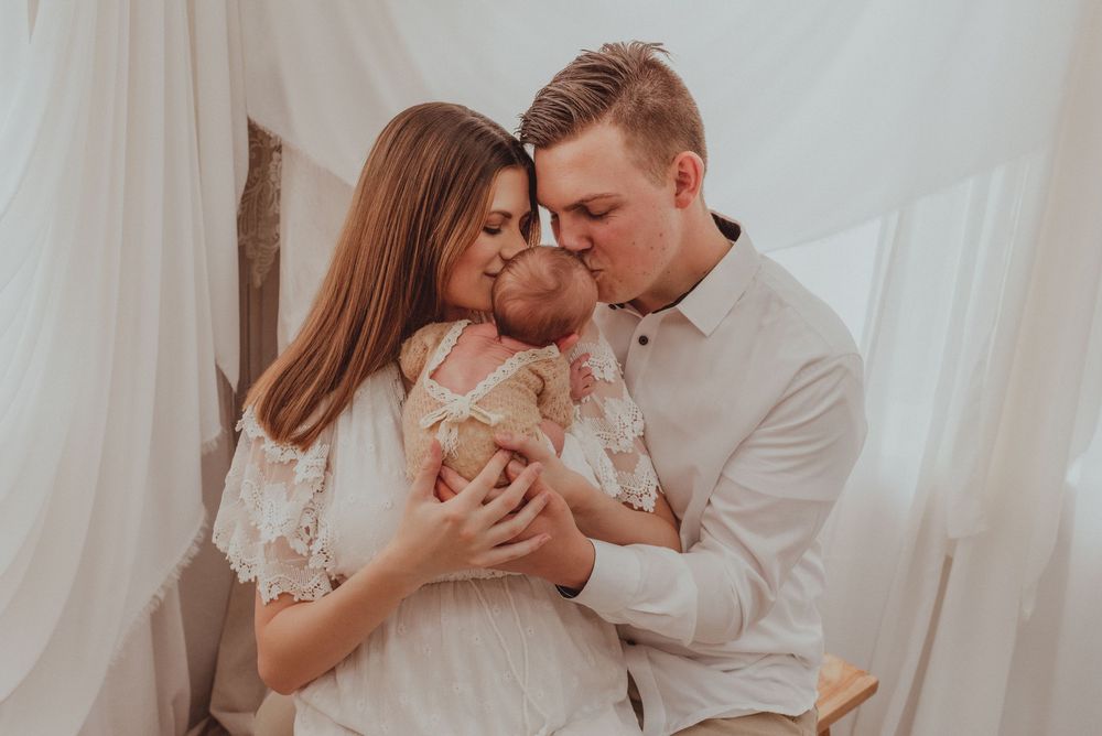 Four tender moments captured of a couple in white outfits embracing and sharing an intimate connection in a light airy setting.