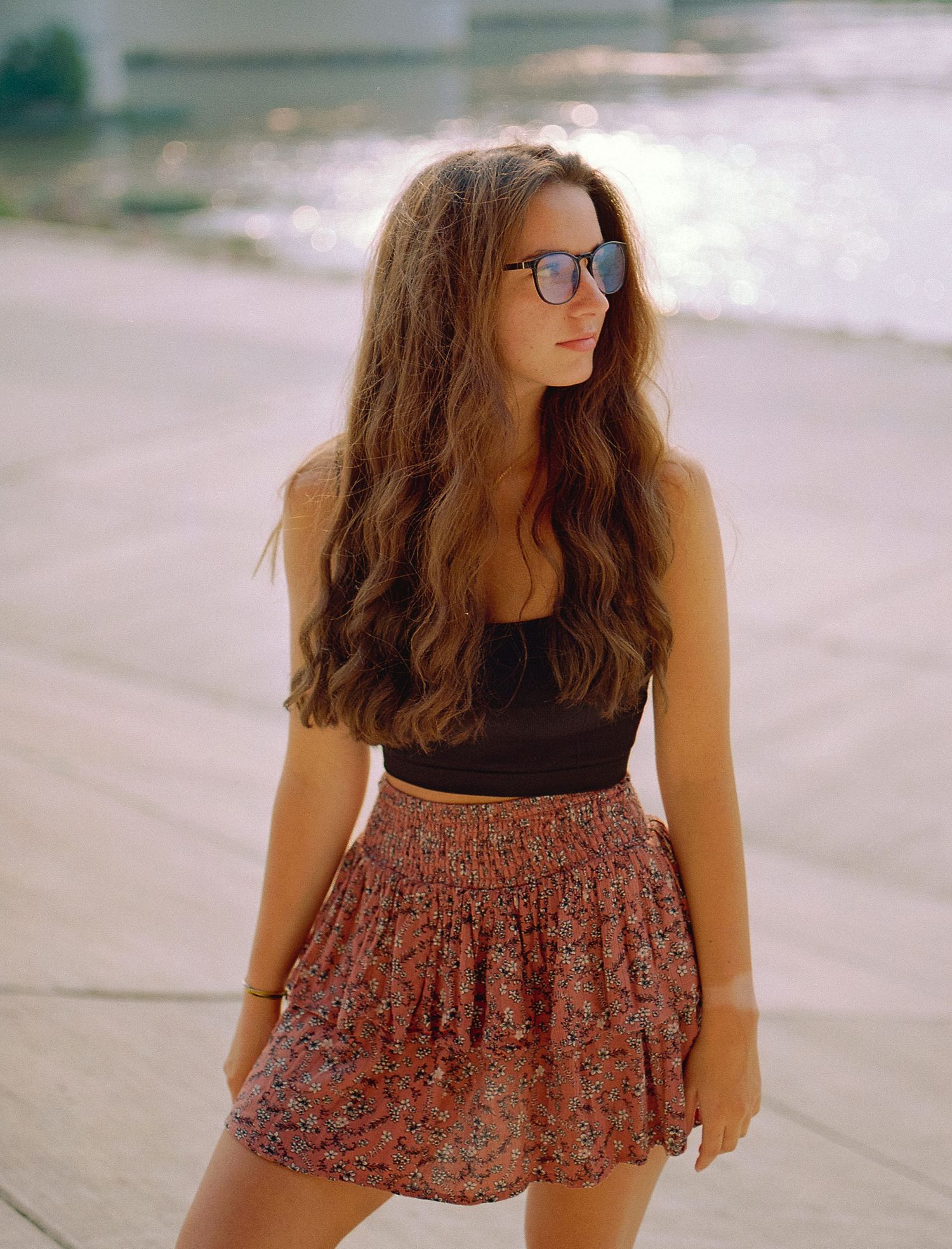 Summer fashion portrait with retro glasses, crop top and floral skirt.