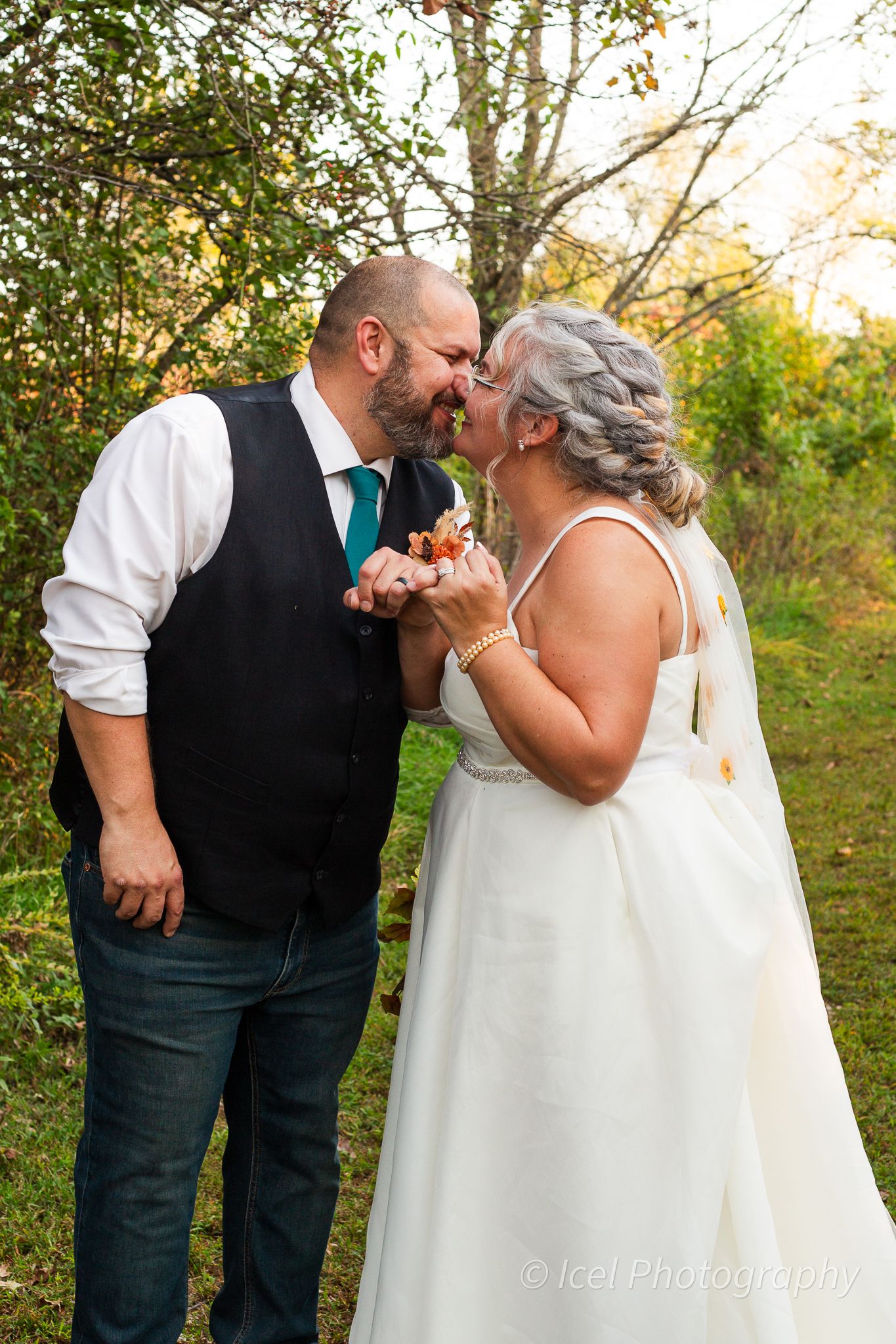 Bride and groom walking through a dreamy forest path, hand-in-hand, as newlyweds on their special day.