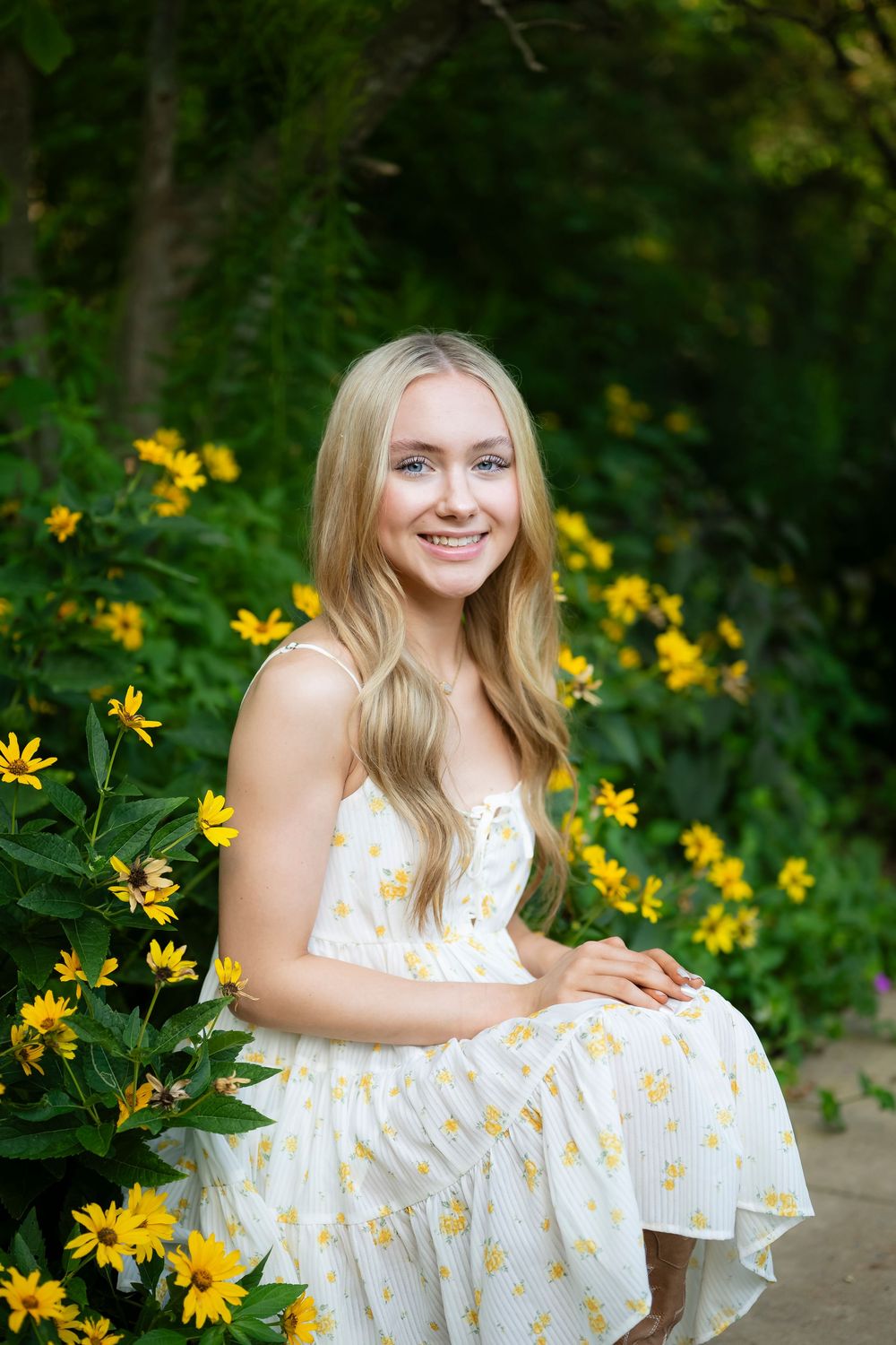 Yellow wildflowers frame a white summer dress in an outdoor garden setting.