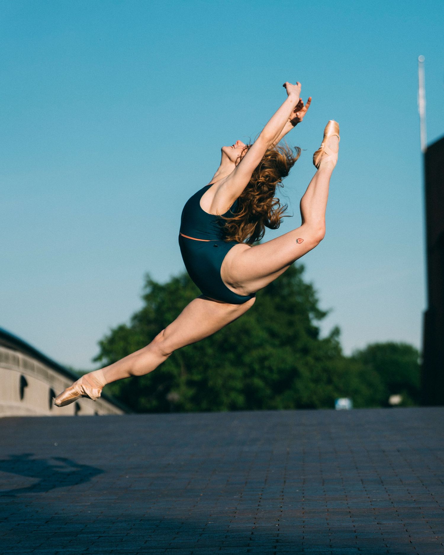 Petite Indy Ballet dancer performing a firebird at sunrise during a ballet photography session in White River State Park, Indianapolis