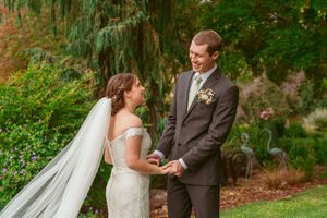 A couple shares an intimate moment together in a lush garden setting during their wedding ceremony.