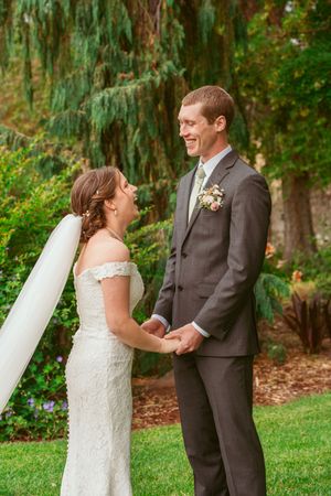 A couple shares a joyful moment together during their outdoor garden wedding ceremony.