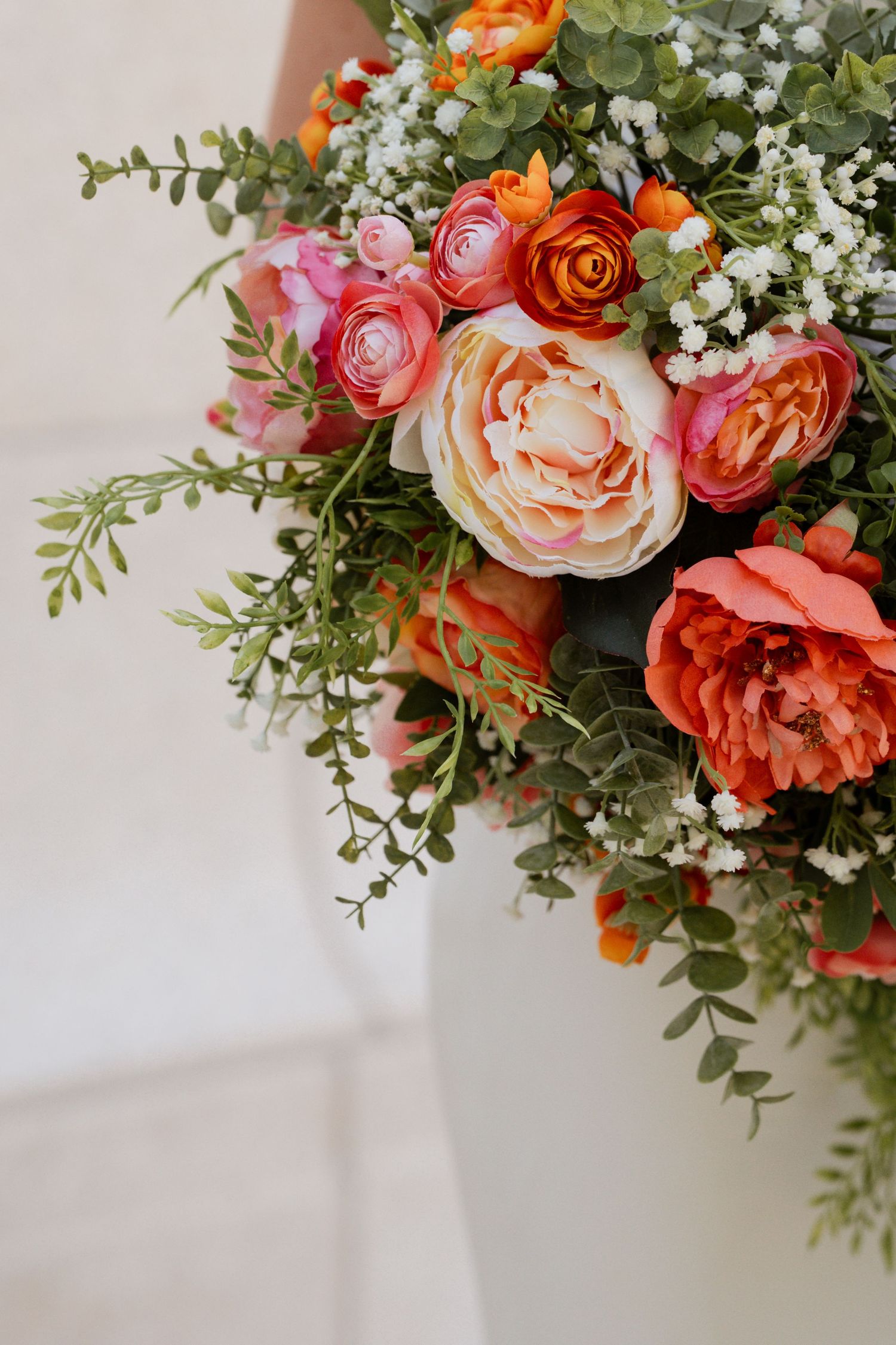 Elegant Des Moines wedding bouquet with peach, orange, and white flowers in natural setting