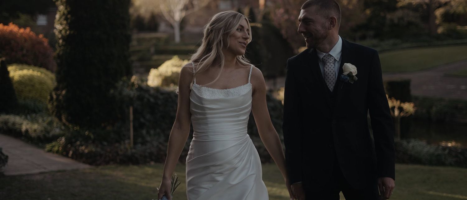 Newlywed couple embrace in front of historic domed building during wedding photo session.