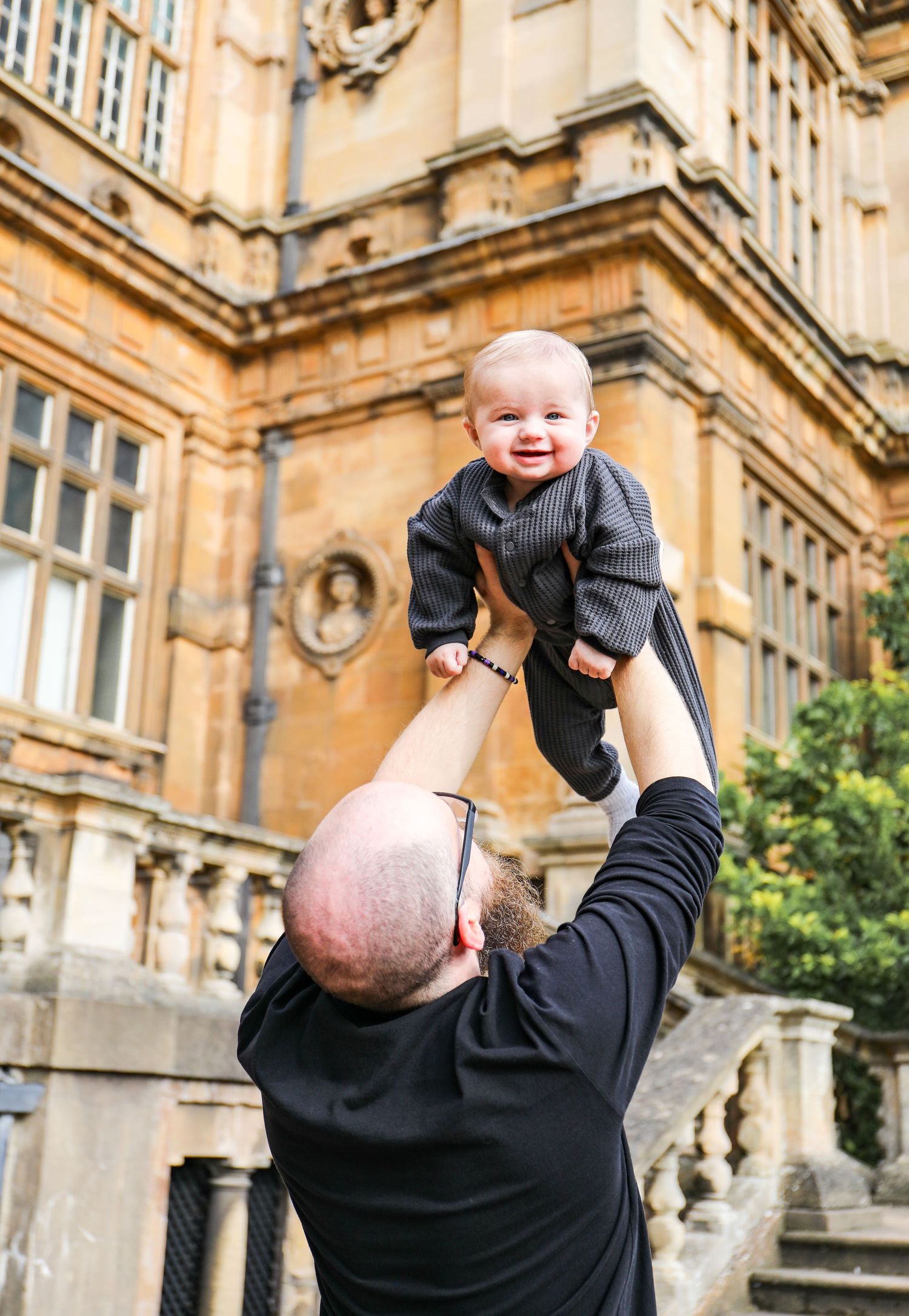 A joyful moment captured on a autumn day outside an ornate stone building during family shoot in Nottingham