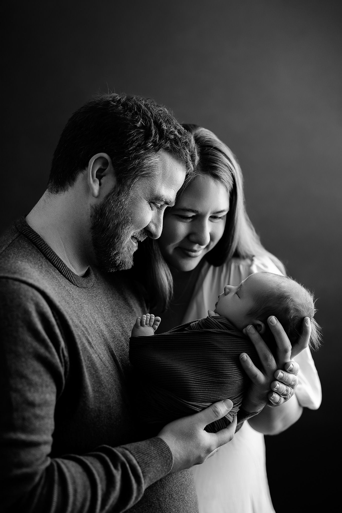 new mom and dad gaze lovingly at their baby boy