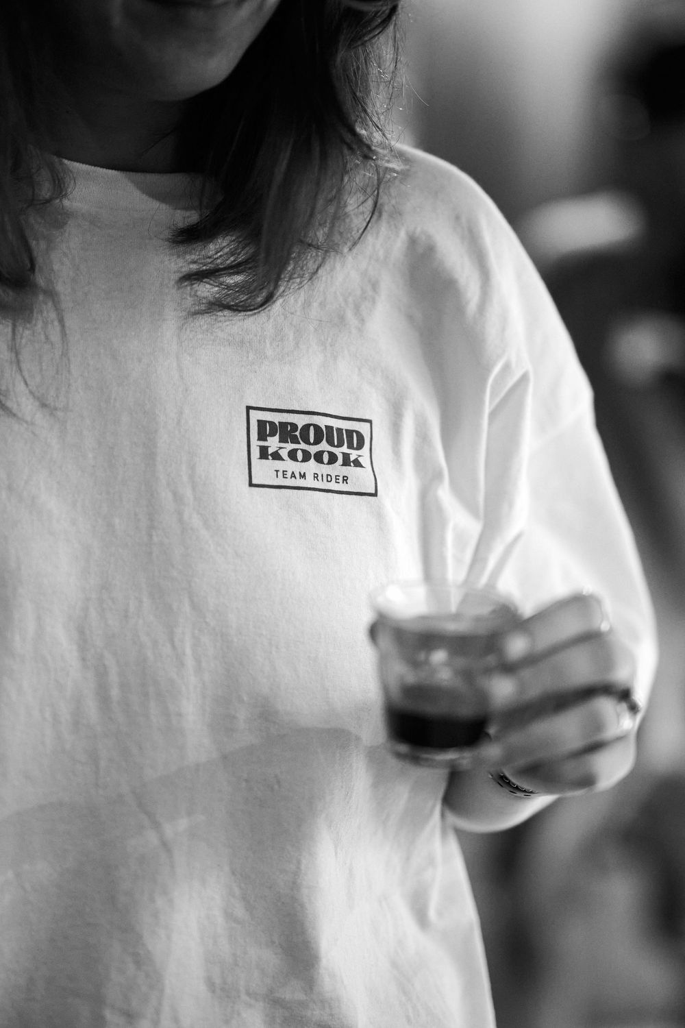 Series of black and white closeup photos showing someone wearing a white t-shirt with text in casual poses.