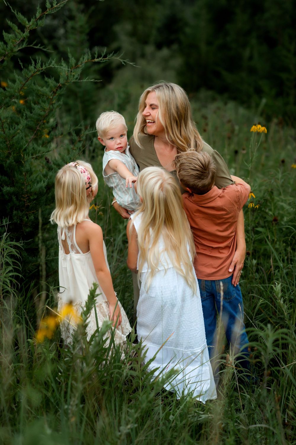 People walking through a field of wildflowers and tall grass on a summer day, captured in progression.