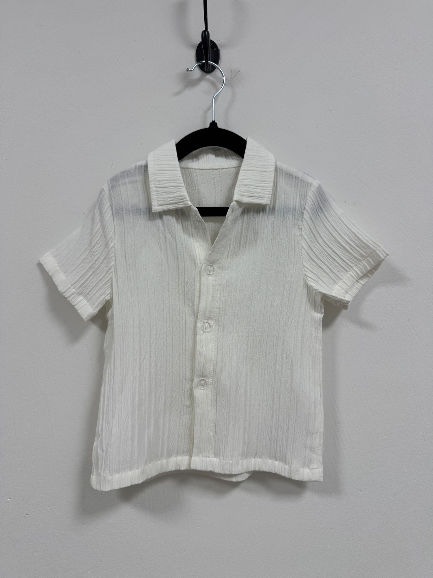 Vintage white cropped button-down collared shirt with short sleeves and pintuck details displayed on a hanger.