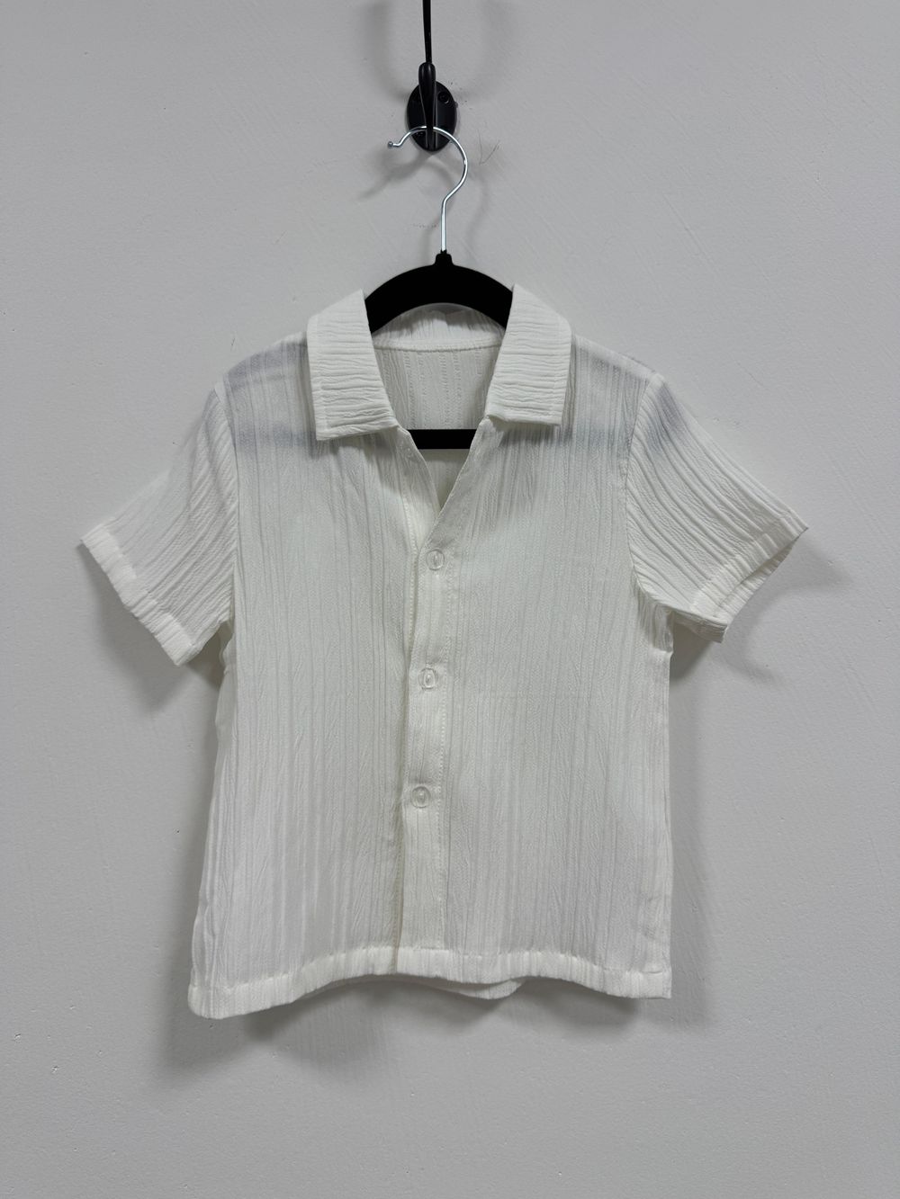 Vintage white cropped button-down collared shirt with short sleeves and pintuck details displayed on a hanger.
