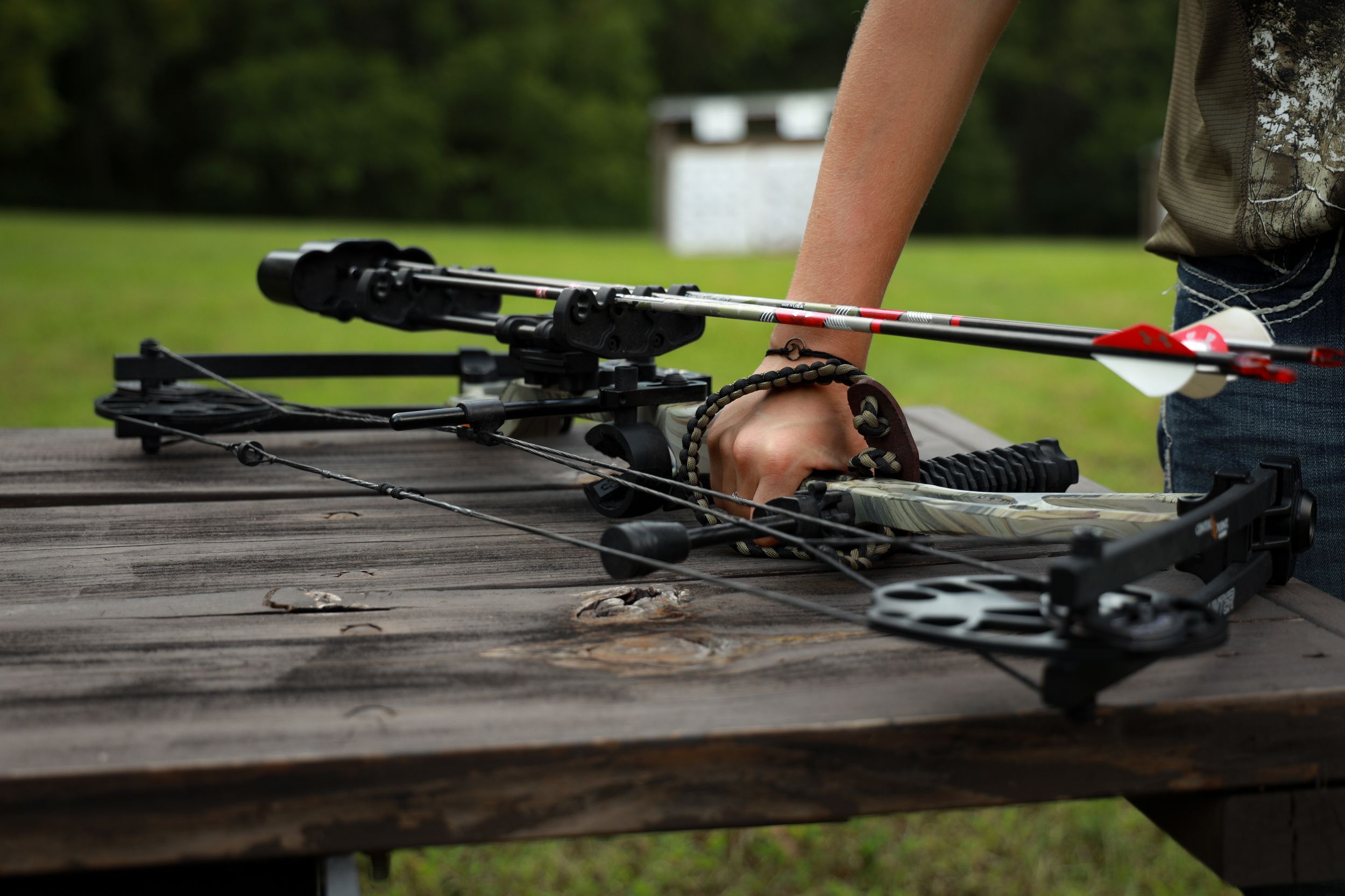 Photo of a woman picking up an archery bow
