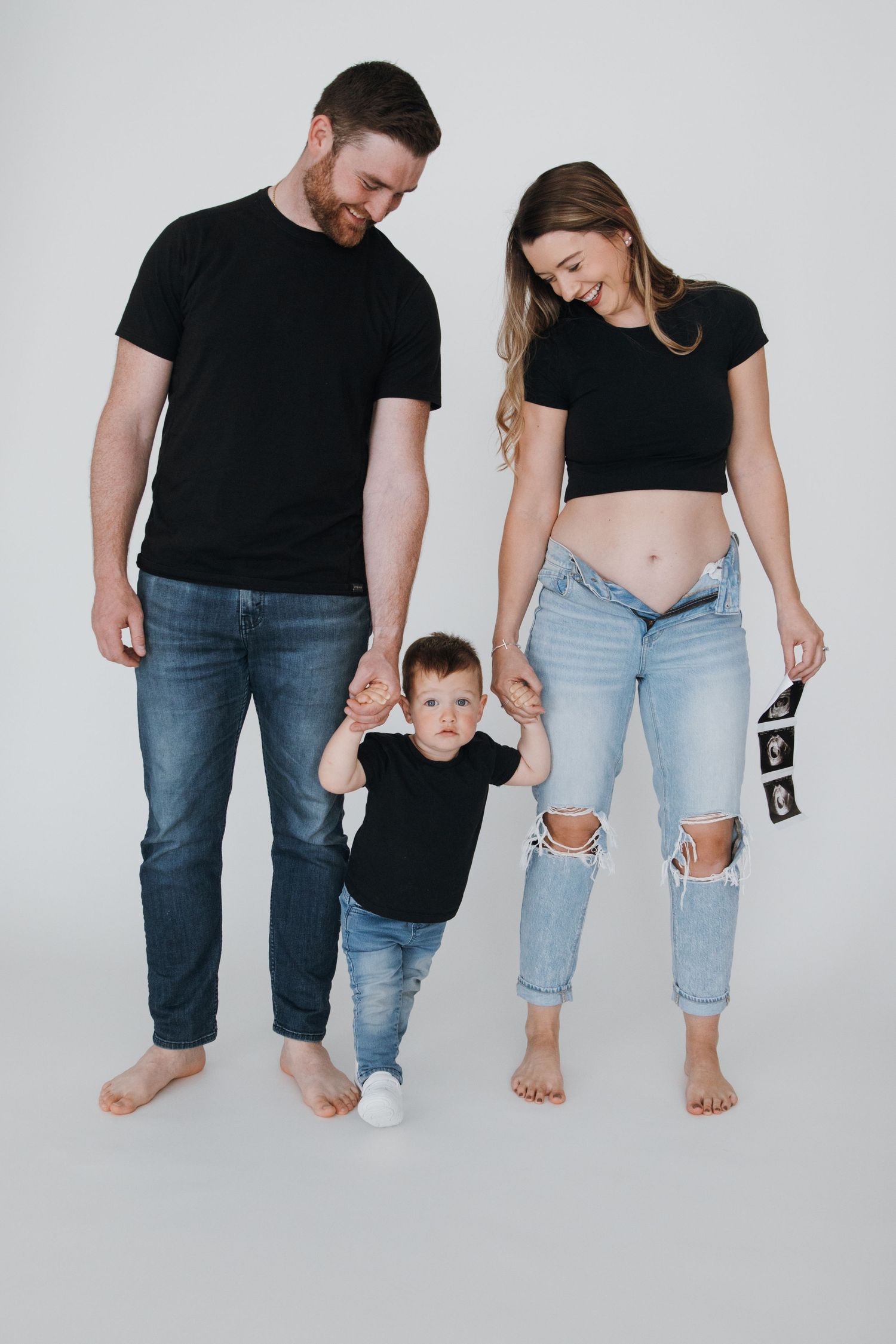 Creative family photo showing legs and feet against white background wearing matching casual outfits.