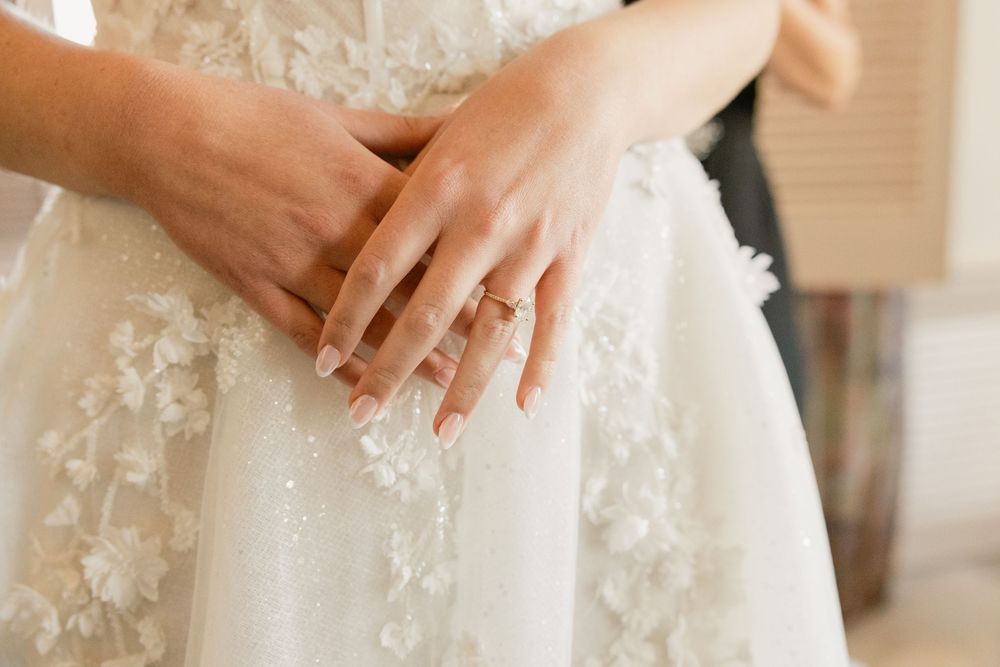 Detail shot of a white lace wedding dress with delicate floral appliques.