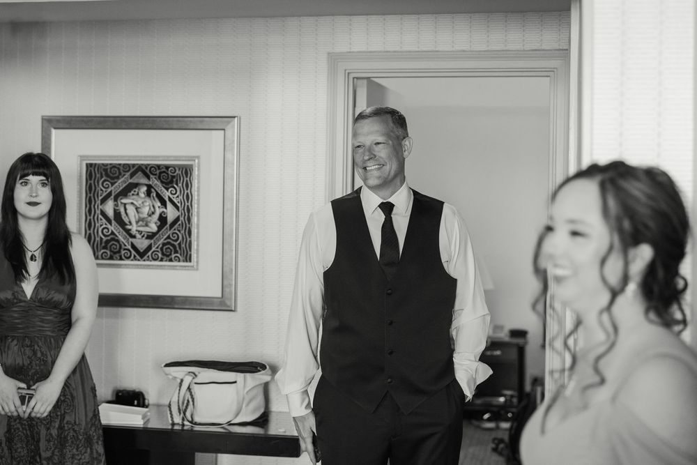 Black and white wedding photography shows an elegant celebration with people gathered in formal attire.