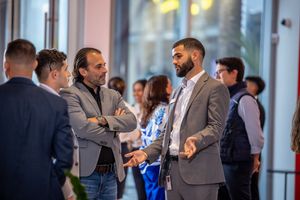 Business professionals networking and mingling at an indoor corporate event or conference.