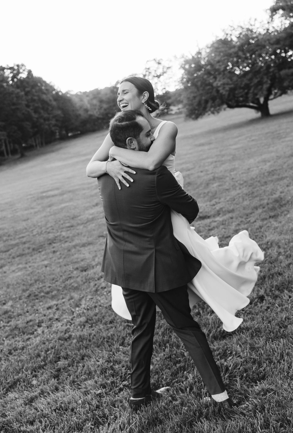 A romantic sequence of black and white photos showing a couple dancing and dipping on a grassy hillside.