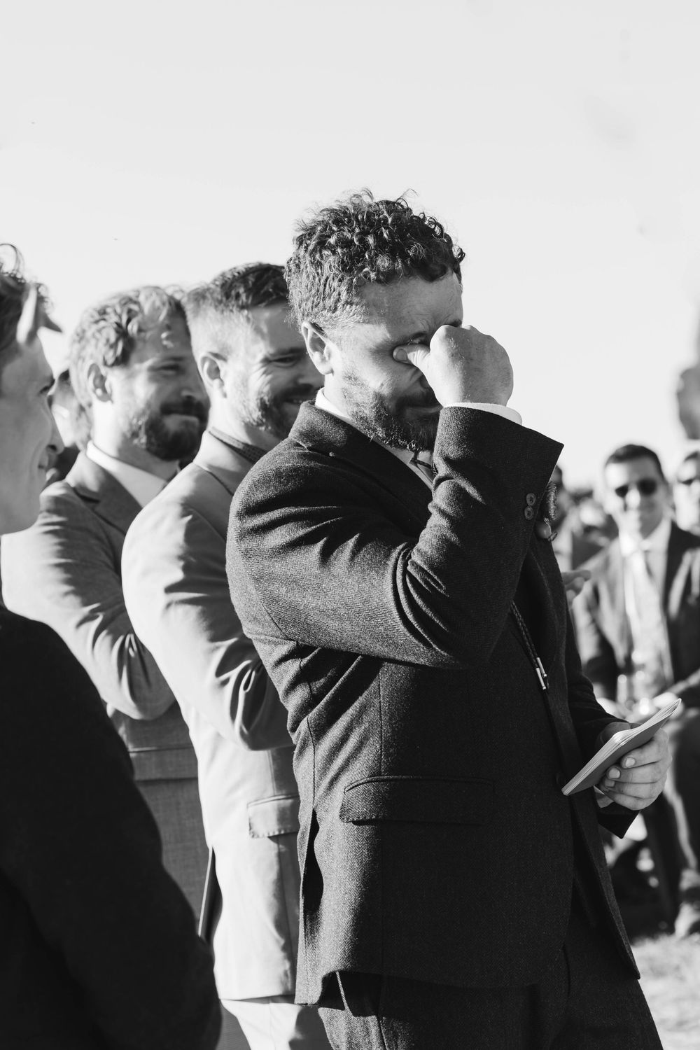 Wedding guests raise their arms in celebration during an outdoor ceremony. Mendocino wedding. Northern California.